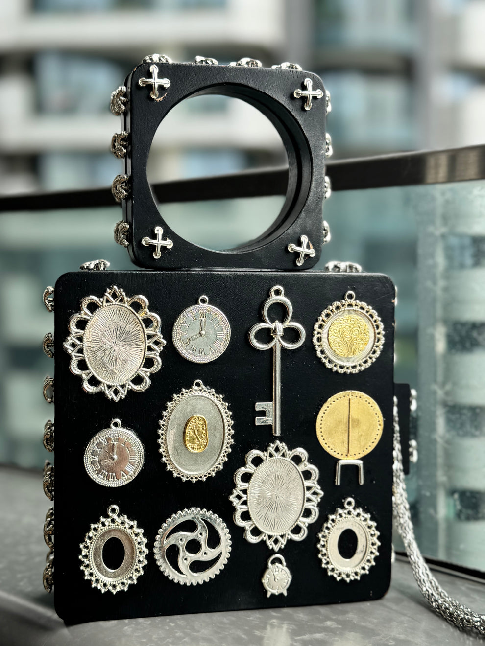 The Royal Timekeeper, a luxurious statement handbag adorned with vintage gold charms